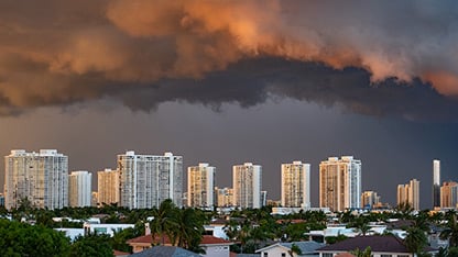 Dark storm clouds loom over the city skyline, creating a dramatic and ominous atmosphere