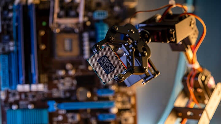 Industrial robotic arm holding a CPU chip