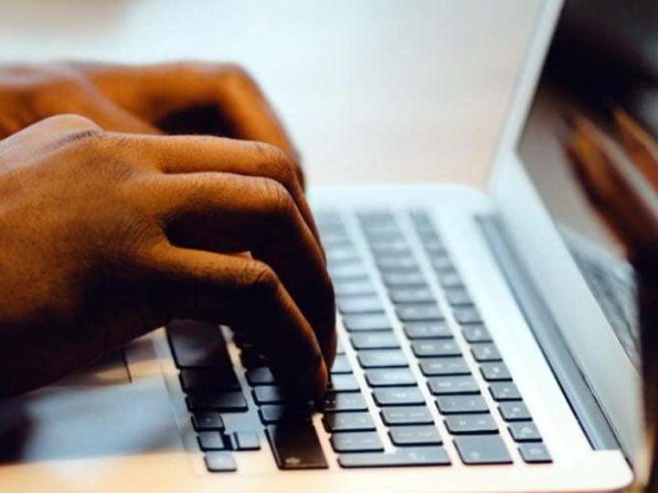 close-up on hands typing on a laptop keyboard