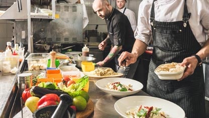 Line sous chef plating food in an upscale restaurant
