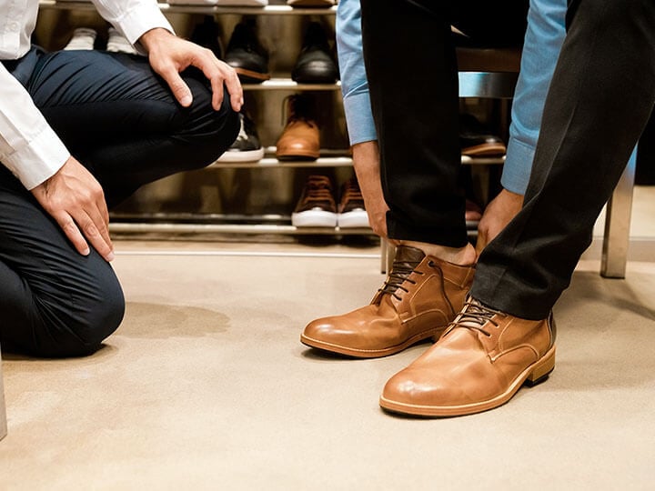 Man trying on a pair of leather shoes in a shoe store
