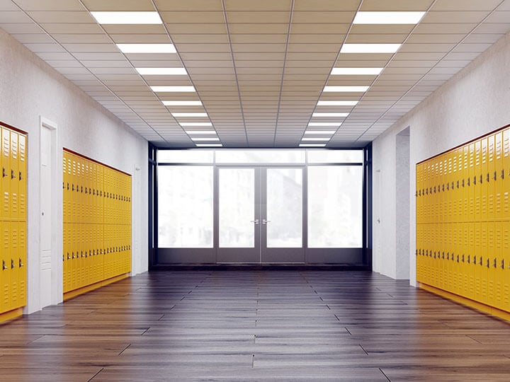 Field Labeling of Fire Doors with fire doors at the end of a school hallway with yellow lockers running down the hallway
