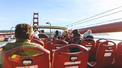 Tourists sitting in an open air tour bus on the Golden Gate Bridge