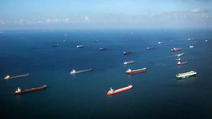 Collection of cargo ships at sea sailing to port