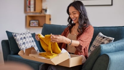Happy young woman checking clothes at home