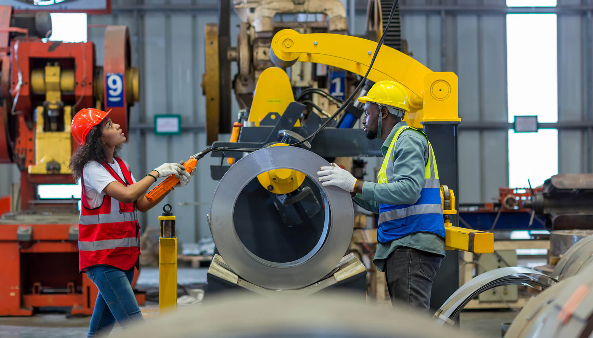 Facility workers speaking while working over a machine