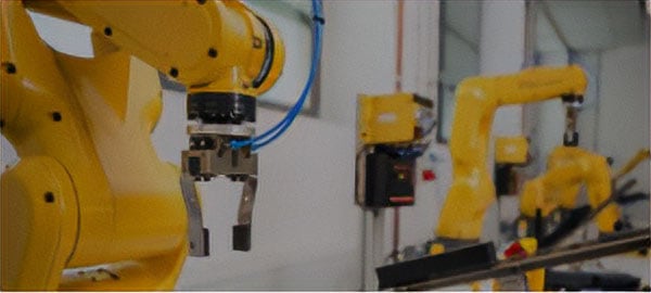 Yellow robotic arms on an automation line