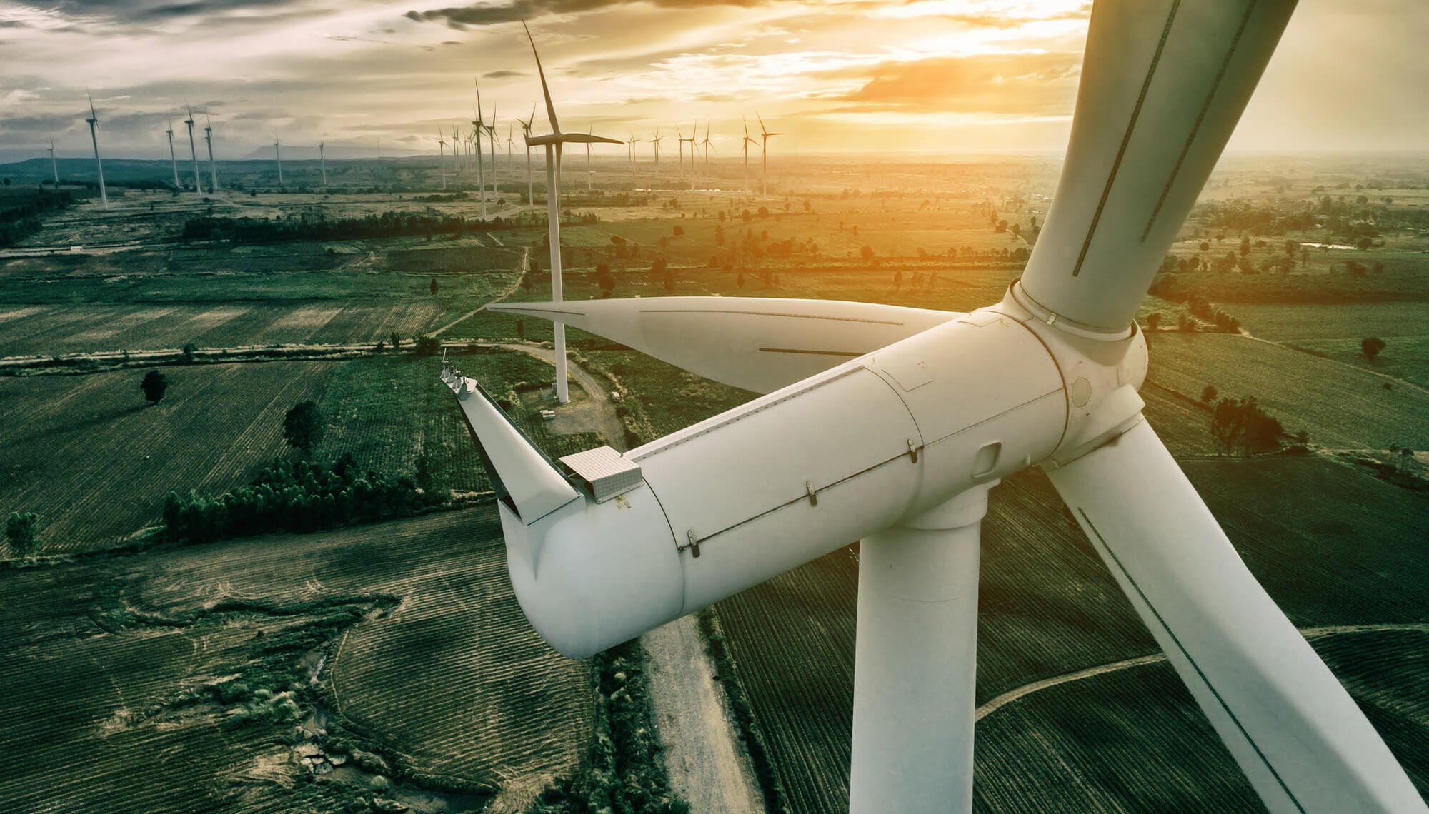 Wind Turbines over an open field at sunset