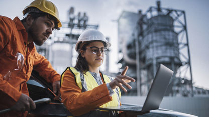 Team of field engineers working reviewing reports on a laptop
