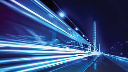 a blue abstract image of fast travel at night with blurred lighting which infers speed.
